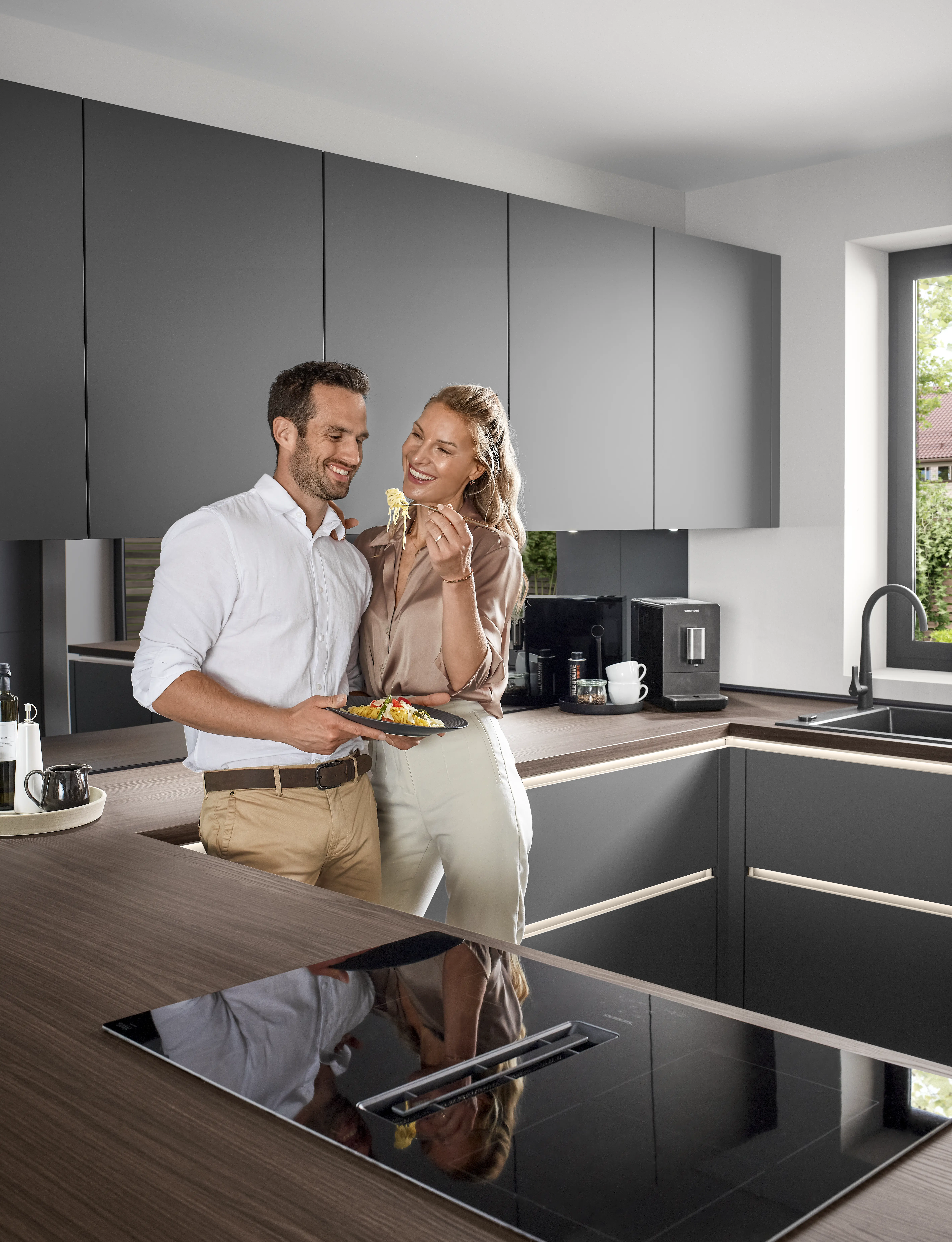 Moderne U-förmige Küche in hellem Raum – matte dunkelgraue Fronten ohne Griffe Moderne U-förmige Küche in hellem Raum – matte dunkelgraue Fronten ohne Griffe