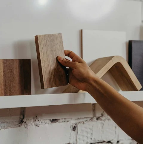 Kunde hält Muster einer Holzplatte in der Hand – Entnahme vom Wandboard Kunde hält Muster einer Holzplatte in der Hand – Entnahme vom Wandboard