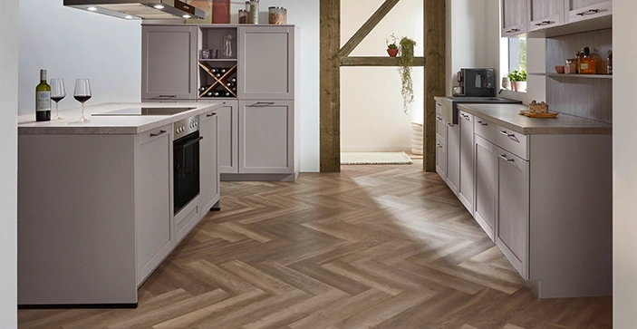 Blick auf mehrzeilige beige Küche mit Rahmenfront und Küchen Blick auf mehrzeilige beige Küche mit Rahmenfront und Küchen