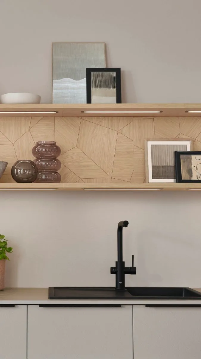 Moderne Küchenregale aus Holz über einer schwarzen Spüle und Armatur. Die Regale sind mit gerahmten Bildern und Glasvasen dekoriert. Moderne Küchenregale aus Holz über einer schwarzen Spüle und Armatur. Die Regale sind mit gerahmten Bildern und Glasvasen dekoriert.