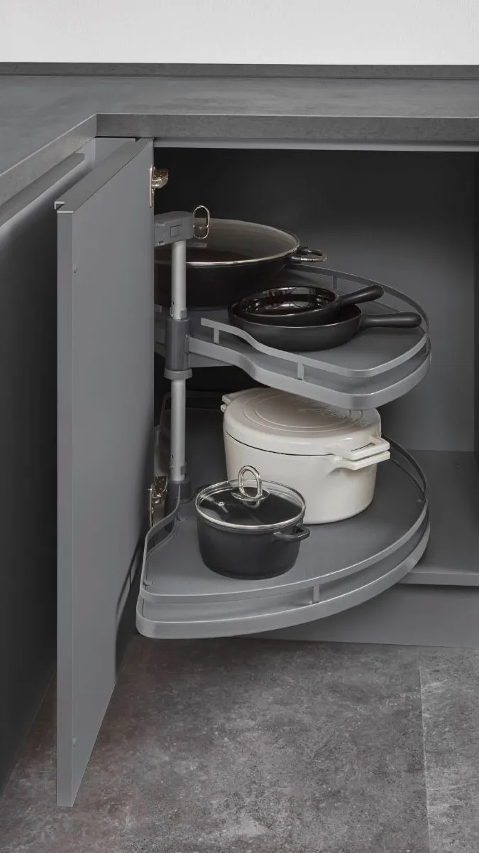 Geöffneter Küchenunterschrank mit einem Schwenkauszug-System in Grau, das Töpfe und Pfannen im Eckschrank sichtbar und zugänglich macht. Geöffneter Küchenunterschrank mit einem Schwenkauszug-System in Grau, das Töpfe und Pfannen im Eckschrank sichtbar und zugänglich macht.