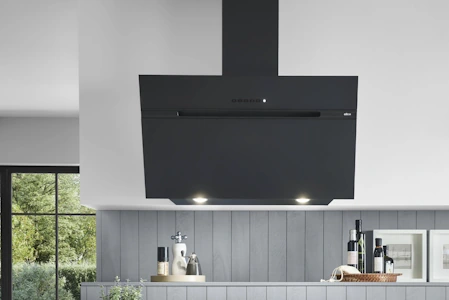 Eine schwarze Dunstabzugshaube in einer Küche mit grauer Holzverkleidung Eine schwarze Dunstabzugshaube in einer Küche mit grauer Holzverkleidung