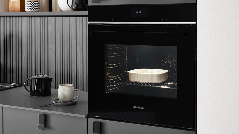 Ausschnitt einer einzeiligen Küche mit Hochschrank, in dem ein Ofen einbaut ist. Die Fronten sind grau. Ausschnitt einer einzeiligen Küche mit Hochschrank, in dem ein Ofen einbaut ist. Die Fronten sind grau.