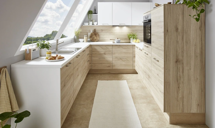 Moderne Küche mit weißen Oberschränken und hellen Holzfronten, viel Tageslicht und einer freundlichen, warmen Atmosphäre. Moderne Küche mit weißen Oberschränken und hellen Holzfronten, viel Tageslicht und einer freundlichen, warmen Atmosphäre.