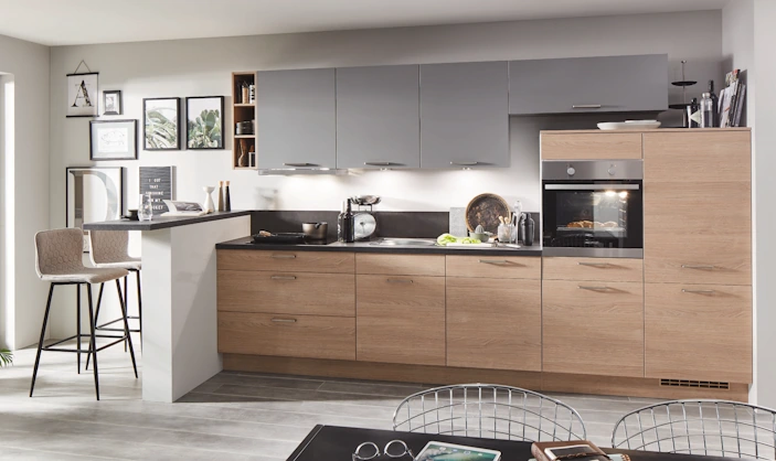 Moderne Küche mit Holzfronten, grauen Oberschränken und klarer, ruhiger Gestaltung in einem offenen Wohnraum. Moderne Küche mit Holzfronten, grauen Oberschränken und klarer, ruhiger Gestaltung in einem offenen Wohnraum.