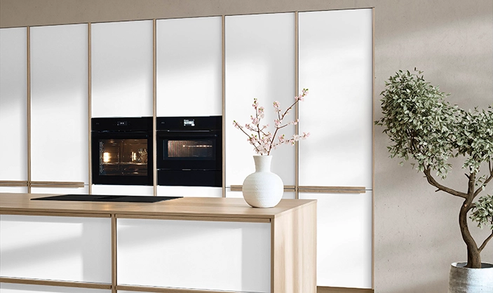 Japandi-Küche in natürlichem Weiß. Sie besteht aus einer Zeile mit Hochschränken sowie einer Insel mit Kochplatte. Japandi-Küche in natürlichem Weiß. Sie besteht aus einer Zeile mit Hochschränken sowie einer Insel mit Kochplatte.