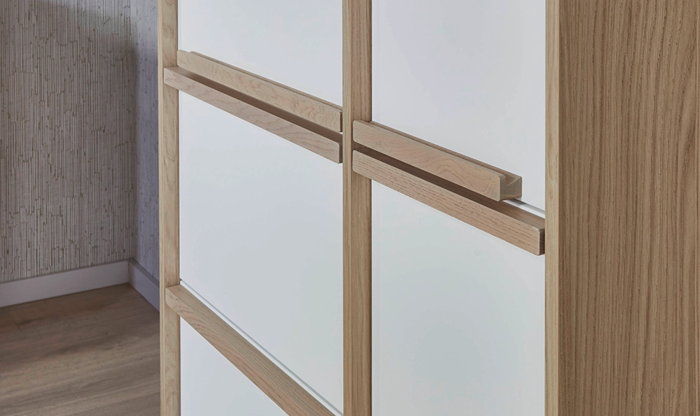 Wir sehen den eine Küchenmöbelfront im Japandi-Stil. Die Fronten sind cremeweiß und die Griffe in einem Eicheton. Wir sehen den eine Küchenmöbelfront im Japandi-Stil. Die Fronten sind cremeweiß und die Griffe in einem Eicheton.