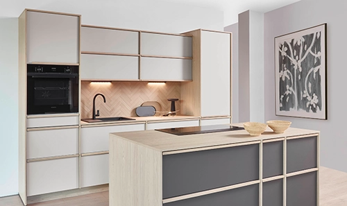 Küche mit Insel im Japandi-Stil. Die Zeile hat eine cremefarbene Front, die Insel eine anthrazitfarbene. Küche mit Insel im Japandi-Stil. Die Zeile hat eine cremefarbene Front, die Insel eine anthrazitfarbene.