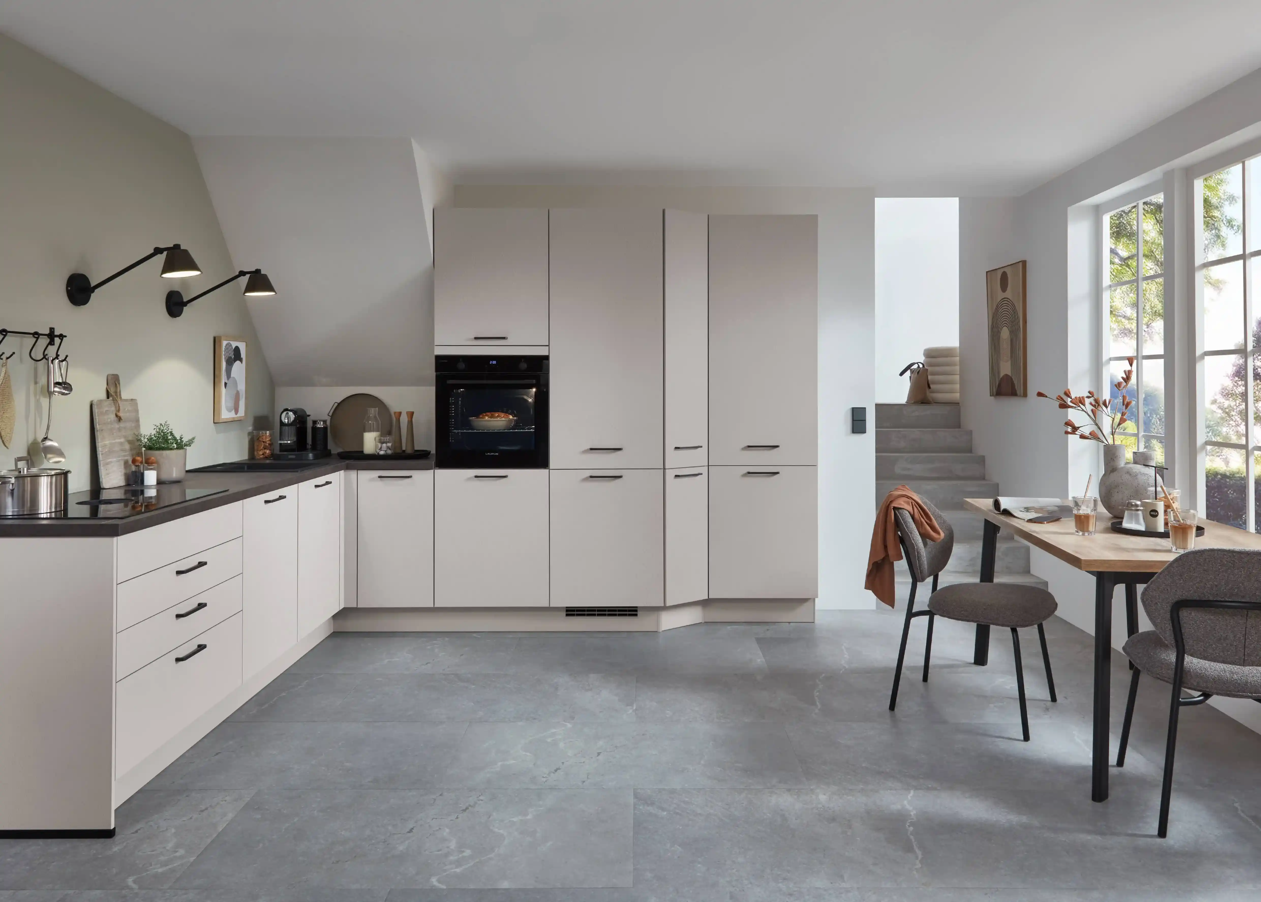 L-Küche mit hellgrauen Mattfronten und schwarzer Arbeitsplatte im klassischen Küchenstil L-Küche mit hellgrauen Mattfronten und schwarzer Arbeitsplatte im klassischen Küchenstil