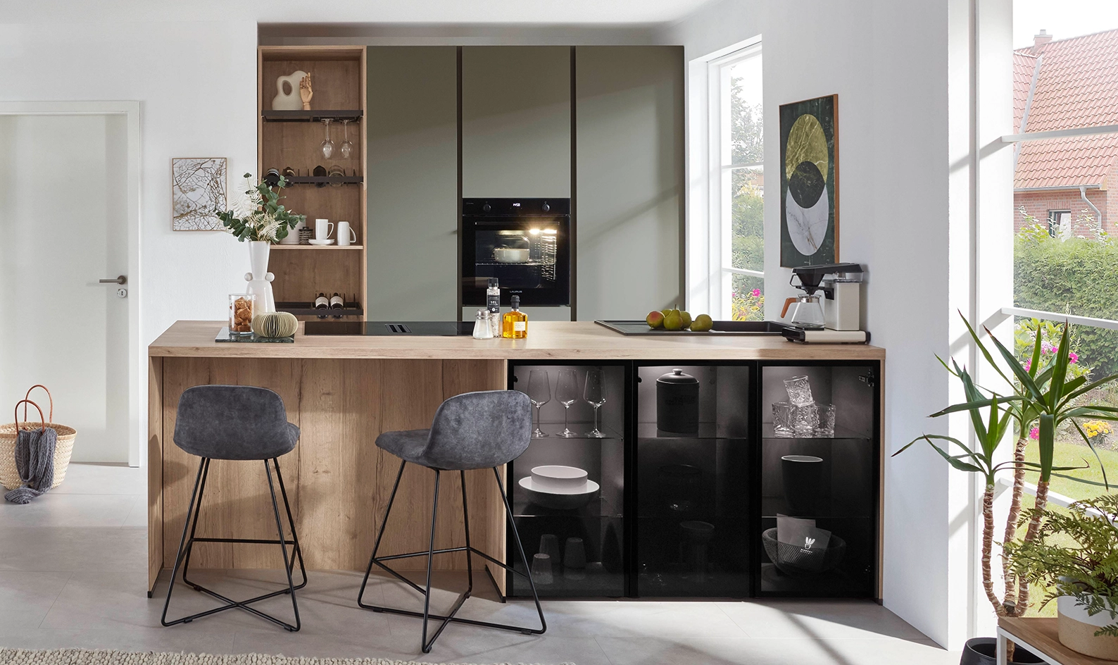 Kleine Küche mit dunkelgrünen Fronten und kleiner Kochinsel. An der Kochinsel ist eine Theke. Kleine Küche mit dunkelgrünen Fronten und kleiner Kochinsel. An der Kochinsel ist eine Theke.