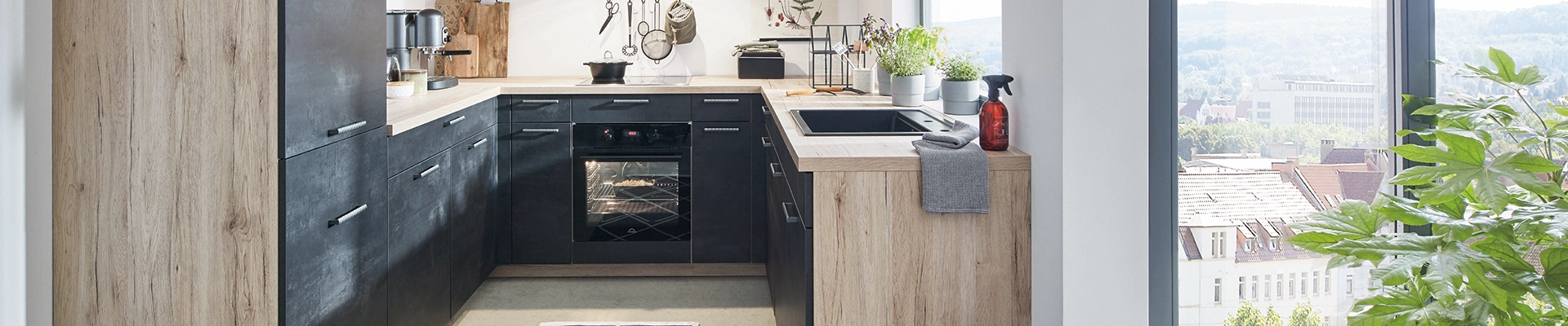 Moderne U‑Küche mit dunklen Fronten, warmen Holzakzenten, großem Fenster mit Stadtblick und frischen Kräutern auf der Arbeitsplatte. Moderne U‑Küche mit dunklen Fronten, warmen Holzakzenten, großem Fenster mit Stadtblick und frischen Kräutern auf der Arbeitsplatte.