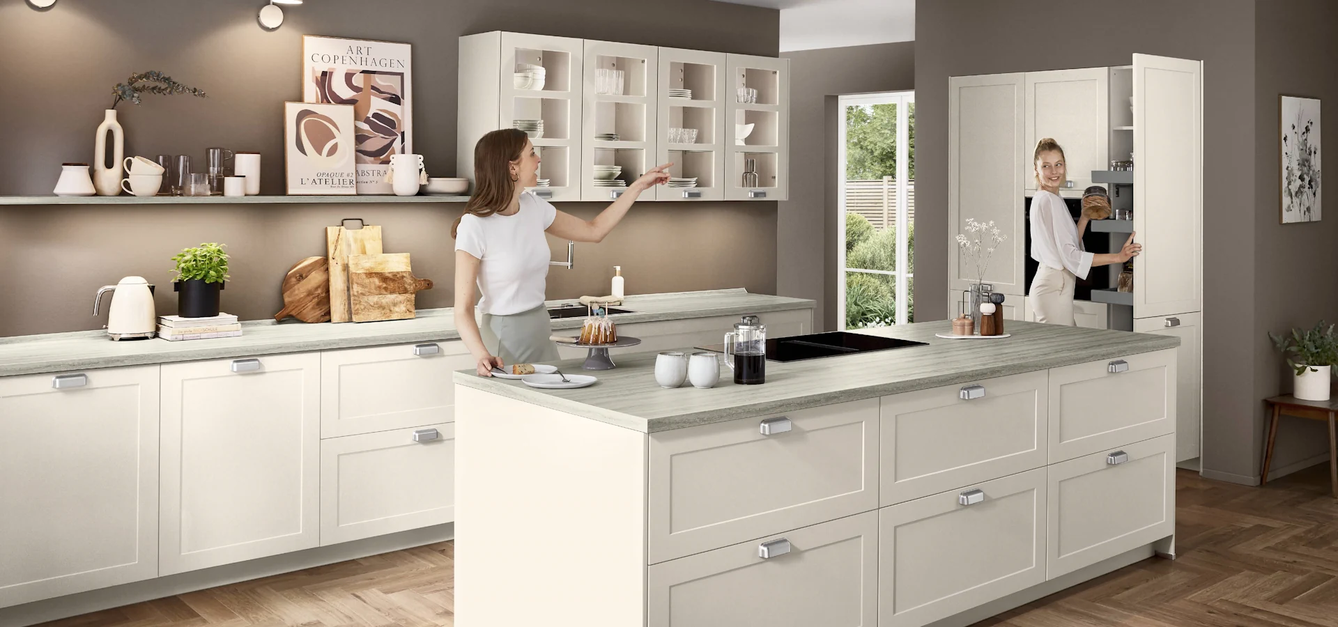 Zwei Frauen sind in einer weißen Küche mit Rahmenfront und bereiten eine Mahlzeit vor. Zwei Frauen sind in einer weißen Küche mit Rahmenfront und bereiten eine Mahlzeit vor.