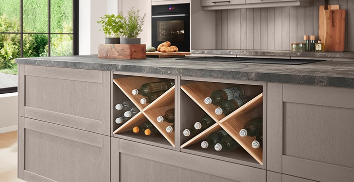 Moderne Küche mit grauen Fronten, dunkler Arbeitsplatte und integriertem Weinregal aus Holz. Moderne Küche mit grauen Fronten, dunkler Arbeitsplatte und integriertem Weinregal aus Holz.
