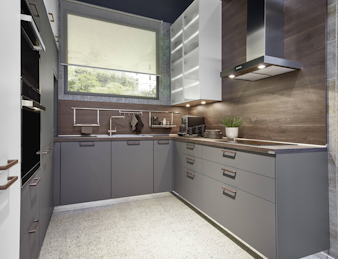 Dunkelgraue U-Küche mit einer Nischenwandverkleidung aus Holz. Dunkelgraue U-Küche mit einer Nischenwandverkleidung aus Holz.