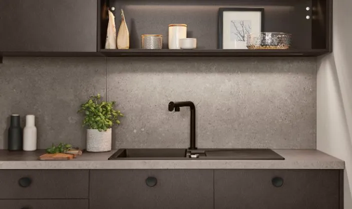 Moderne Küchenzeile in dunklem Braun mit grauer Steinrückwand, schwarzer Armatur, dezenten Dekoelementen und integrierter Beleuchtung. Moderne Küchenzeile in dunklem Braun mit grauer Steinrückwand, schwarzer Armatur, dezenten Dekoelementen und integrierter Beleuchtung.