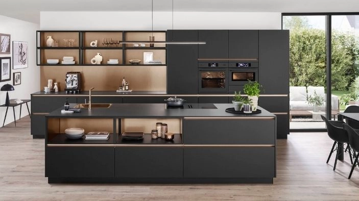 Eine schwarze Küche mit Griffleiste und glatten, matten Fronten. Sie besteht aus einer Zeile mit Vitrinenoberschränken sowie einer Kochinsel. Eine schwarze Küche mit Griffleiste und glatten, matten Fronten. Sie besteht aus einer Zeile mit Vitrinenoberschränken sowie einer Kochinsel.