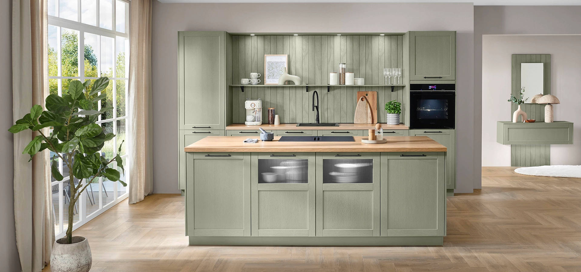 Küche in oliver Farbe mit Rahmenfront. Sie besteht aus einer Zeile mit Hochschränken sowie einer Insel mit Kochstelle. Küche in oliver Farbe mit Rahmenfront. Sie besteht aus einer Zeile mit Hochschränken sowie einer Insel mit Kochstelle.