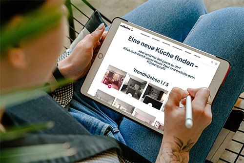Ein User hält ein Tablet, er sucht Kücheninspiration auf der möbelnavi Küchentyp-Seite. Ein User hält ein Tablet, er sucht Kücheninspiration auf der möbelnavi Küchentyp-Seite.