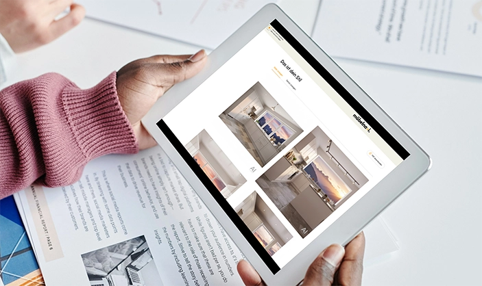 Ein Paar Hände halten einen Tablet. Wir sehen die Küchendesigns, die das möbelnavi KI-Tool für den User erstellt hat. Ein Paar Hände halten einen Tablet. Wir sehen die Küchendesigns, die das möbelnavi KI-Tool für den User erstellt hat.