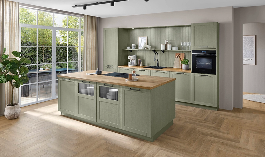 Mediterrane Küche mit oliv grünen Rahmenfronten. Sie besteht aus einer Zeile mit zwei Hochschränken sowie einer Kochinsel. Mediterrane Küche mit oliv grünen Rahmenfronten. Sie besteht aus einer Zeile mit zwei Hochschränken sowie einer Kochinsel.