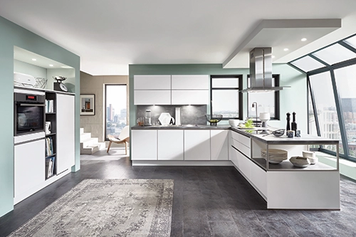 Helle, moderne Küche mit weißen Fronten, großer Fensterfront und offener Raumaufteilung. Helle, moderne Küche mit weißen Fronten, großer Fensterfront und offener Raumaufteilung.