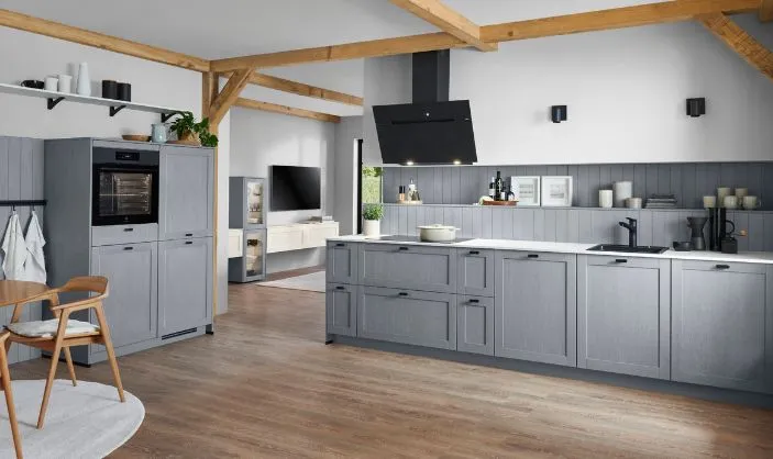 Graue Landhausküche mit Holzdetails, moderner Haube und offenem Wohnbereich. Graue Landhausküche mit Holzdetails, moderner Haube und offenem Wohnbereich.