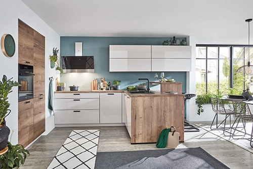 Moderne Küche mit weiß glänzenden Fronten, Holzakzenten und kleiner Kochinsel. Moderne Küche mit weiß glänzenden Fronten, Holzakzenten und kleiner Kochinsel.