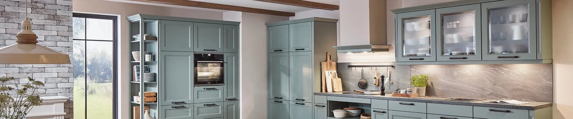 Landhausküche in sanftem Grün mit Glastüren, Steinrückwand und Holzdetails. Landhausküche in sanftem Grün mit Glastüren, Steinrückwand und Holzdetails.