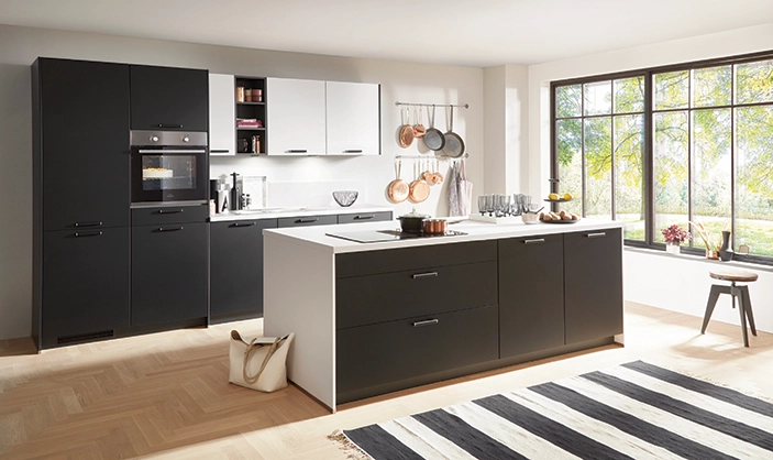 Helle Küche mit schwarzer Kochinsel, weißen Oberschränken und großer Fensterfront. Helle Küche mit schwarzer Kochinsel, weißen Oberschränken und großer Fensterfront.