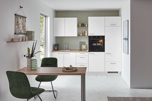 Weiße Pantryküche in einer Nische. Die Arbeitsplatte hat einen Holzton. Weiße Pantryküche in einer Nische. Die Arbeitsplatte hat einen Holzton.