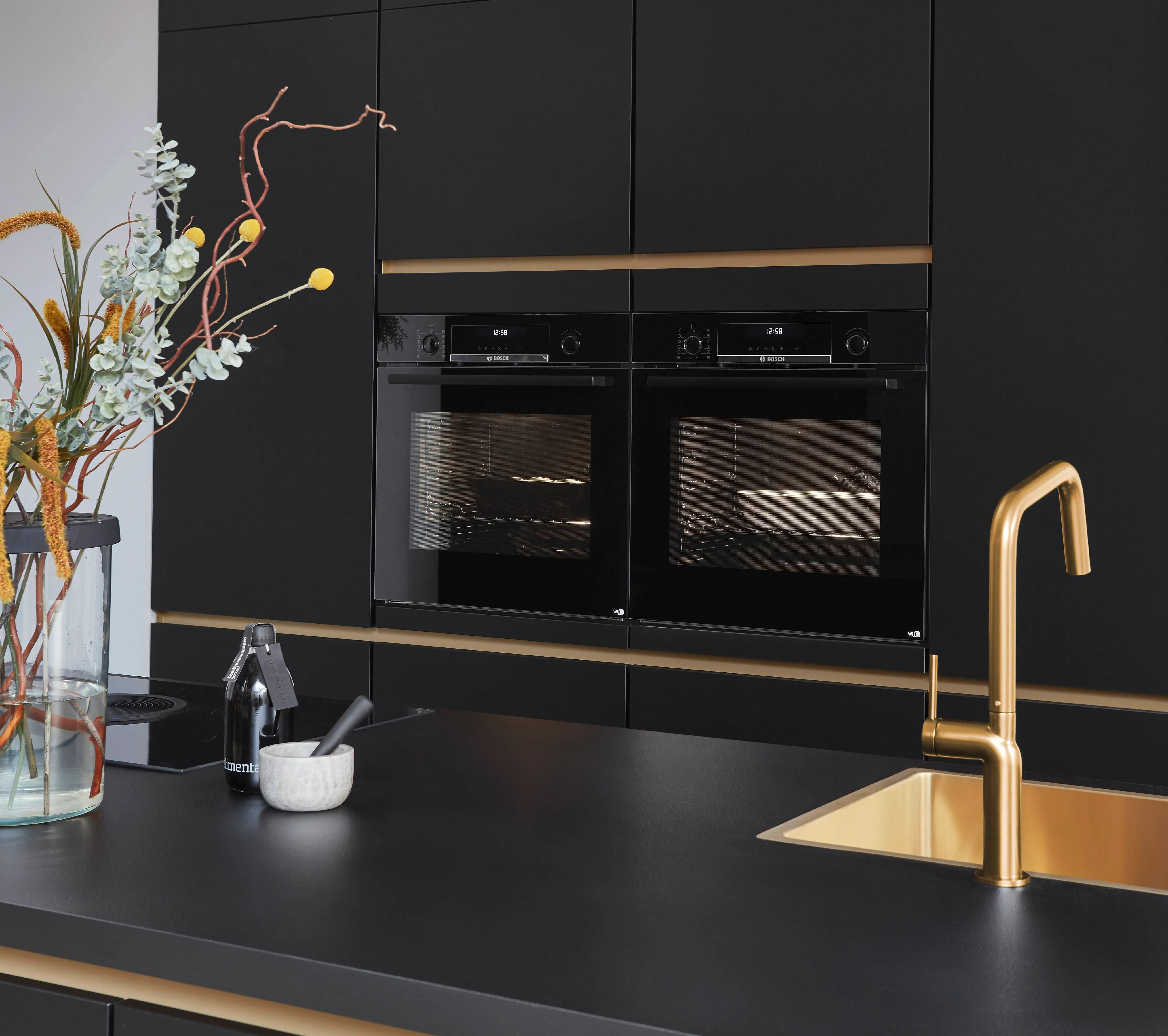 Schwarze grifflose Inselküche mit goldenen Akzenten als Beispiel für modernes Küchendesign und Inspiration für eine moderne Küche Schwarze grifflose Inselküche mit goldenen Akzenten als Beispiel für modernes Küchendesign und Inspiration für eine moderne Küche