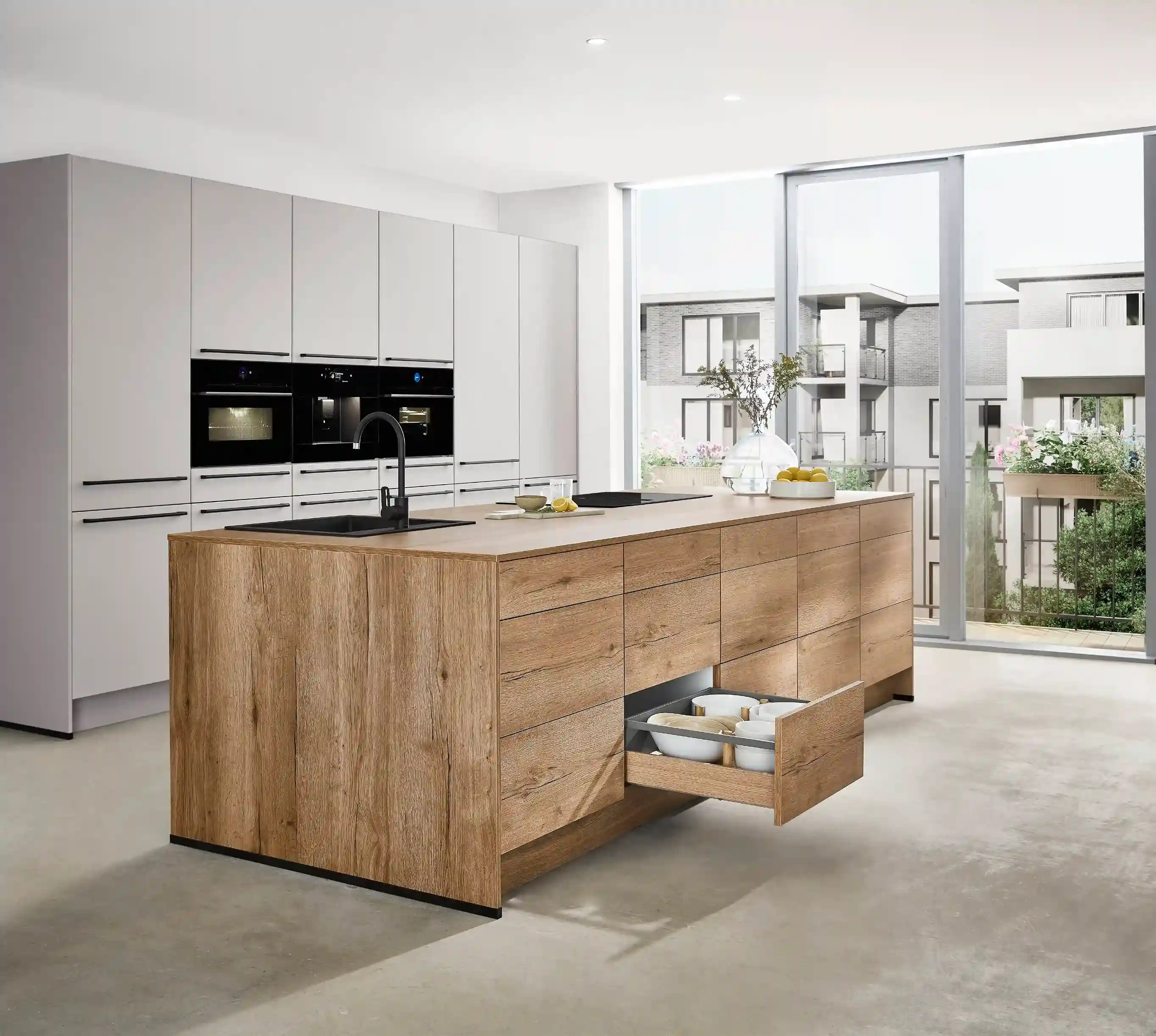 Kücheninsel mit geöffneter Schublade und Auszug als clevere Stauraumlösung in der Singleküche Kücheninsel mit geöffneter Schublade und Auszug als clevere Stauraumlösung in der Singleküche