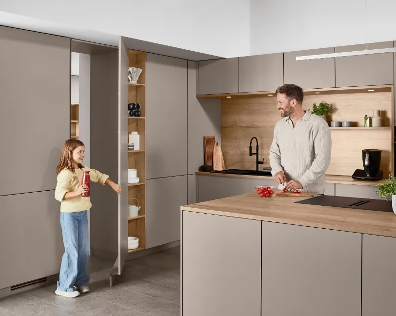 Smarte Küche mit offenem Vorratsschrank und Kücheninsel, an der ein Vater gemeinsam mit seiner Tochter kocht. Smarte Küche mit offenem Vorratsschrank und Kücheninsel, an der ein Vater gemeinsam mit seiner Tochter kocht.