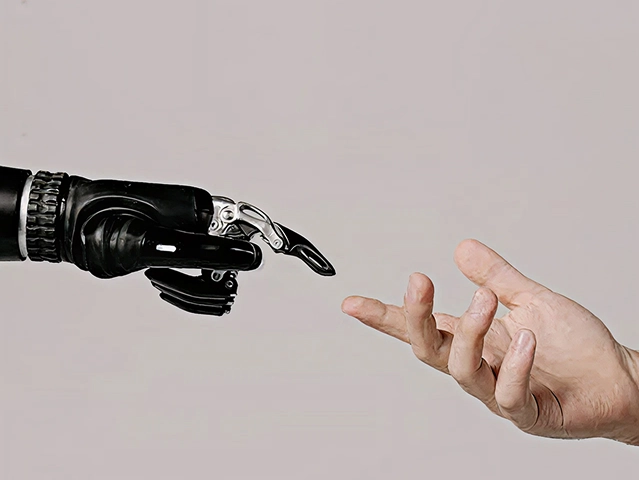 Eine Roboterhand streckt sich einer menschlichen Hand entgegen und symbolisiert die Verbindung zwischen Technologie und Menschlichkeit. Eine Roboterhand streckt sich einer menschlichen Hand entgegen und symbolisiert die Verbindung zwischen Technologie und Menschlichkeit.