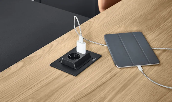 In die Arbeitsplatte integrierte Steckdose mit USB-Ladegerät, Tablet liegt daneben auf Holzoberfläche, modernes und praktisches Detail für die Küchenplanung. In die Arbeitsplatte integrierte Steckdose mit USB-Ladegerät, Tablet liegt daneben auf Holzoberfläche, modernes und praktisches Detail für die Küchenplanung.