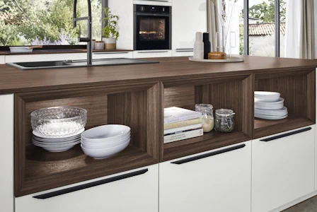 Moderne Küche mit offenen Regalfächern in dunkler Holzoptik, Geschirr und Gläser dekorativ verstaut, helle Fronten und Arbeitsplatte mit Spüle am Fenster. Moderne Küche mit offenen Regalfächern in dunkler Holzoptik, Geschirr und Gläser dekorativ verstaut, helle Fronten und Arbeitsplatte mit Spüle am Fenster.