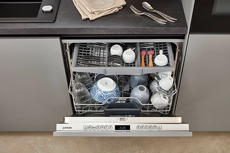 Blick auf eine geöffnete Spülmaschine in einer Küche glatten hellgrauen Fronten. Blick auf eine geöffnete Spülmaschine in einer Küche glatten hellgrauen Fronten.