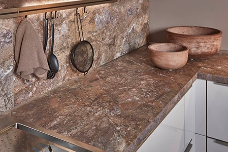 Blick auf eine rostrote Arbeitsplatte in einer Küche mit glänzenden weißen Fronten. Blick auf eine rostrote Arbeitsplatte in einer Küche mit glänzenden weißen Fronten.