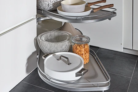 Ausschnitt einer Küche, bei der die Schubladen eine wichtige Rolle in Bezug auf den Preis spielen Wir sehen einen Auszug aus einem Eckschrank mit Pfannen und Töpfen beladen. Ausschnitt einer Küche, bei der die Schubladen eine wichtige Rolle in Bezug auf den Preis spielen Wir sehen einen Auszug aus einem Eckschrank mit Pfannen und Töpfen beladen.