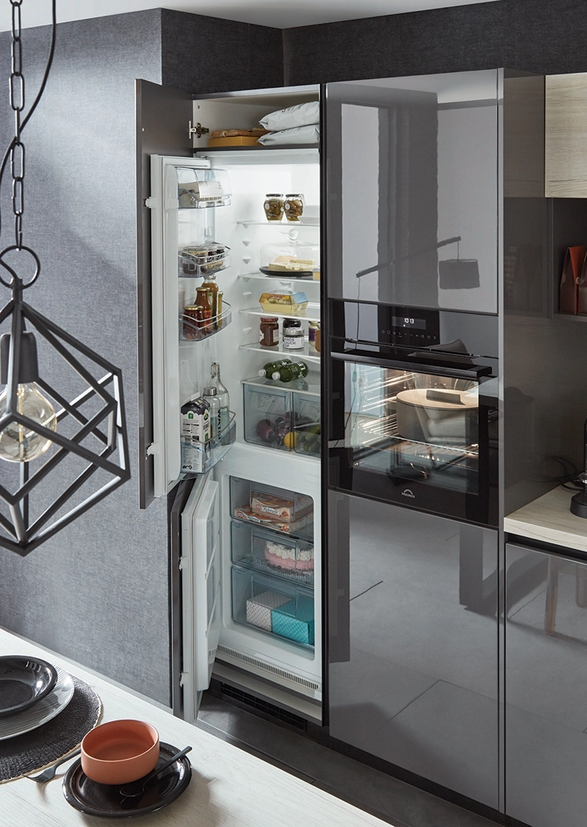 Ausschnitt einer dunkelgrauen Küche mit geöffnetem Kühlschrank und Gefrierschrank. Daneben ein Geräteumbau mit Backofen. Ausschnitt einer dunkelgrauen Küche mit geöffnetem Kühlschrank und Gefrierschrank. Daneben ein Geräteumbau mit Backofen.